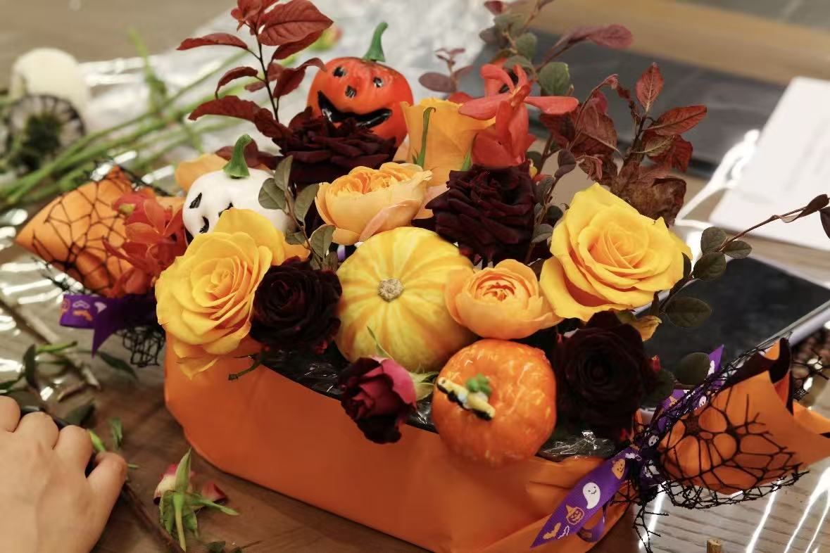 A student arranging a Halloween floral centerpiece in a past class
